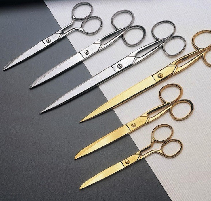 Silver and gold scissors in a row
